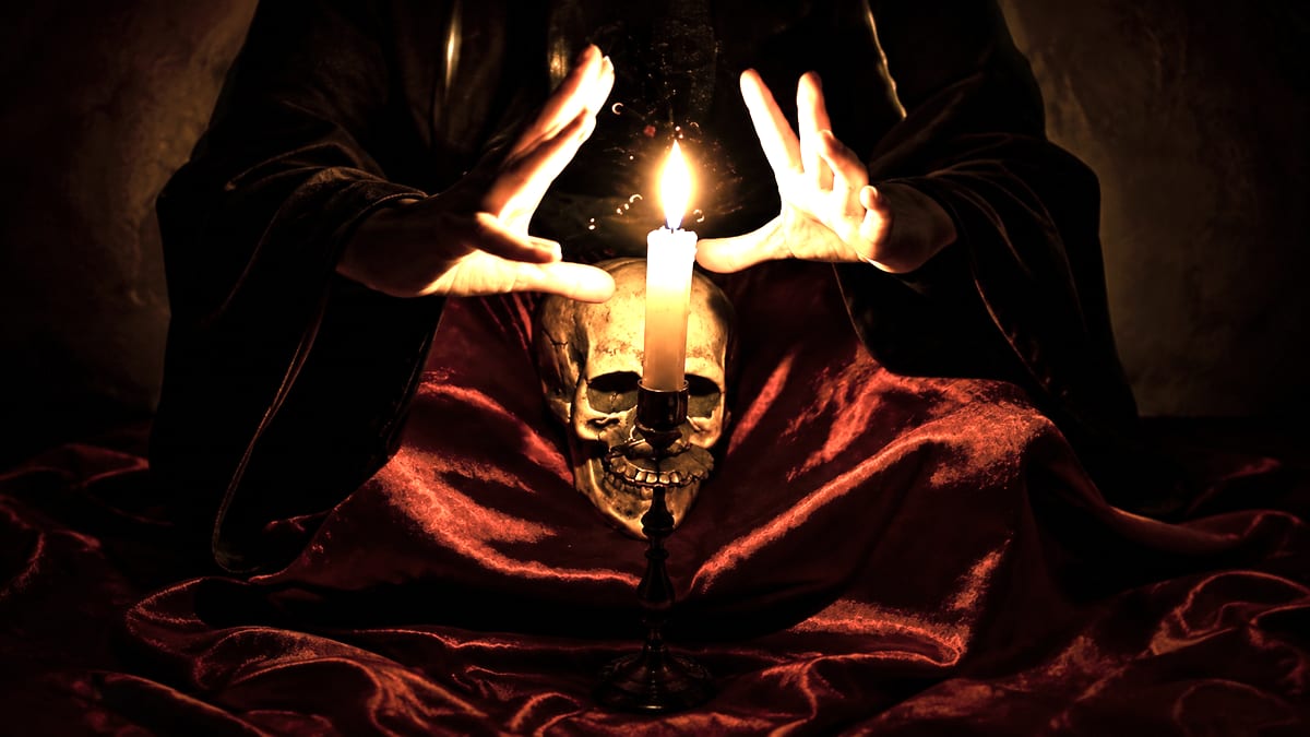 Rituel à la bougie au-dessus d'un crâne, sur une étoffe de velours rouge
